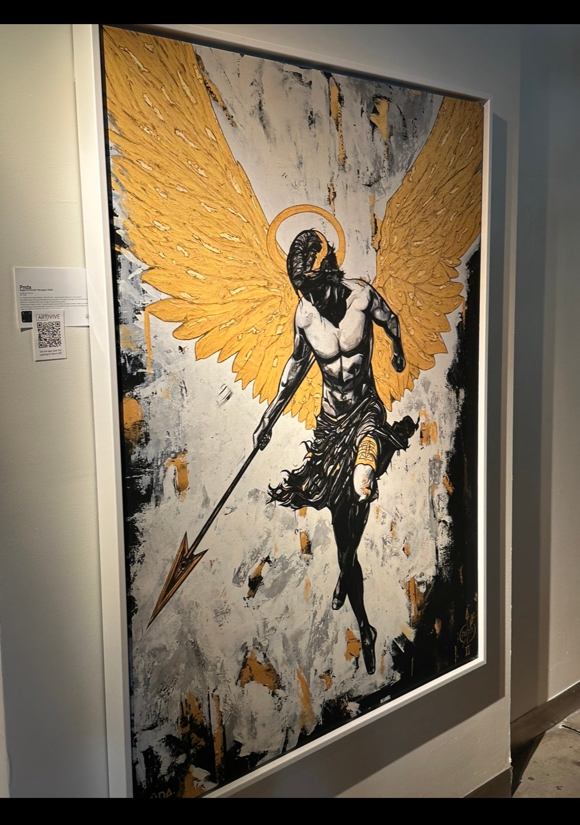 Artistic depiction of an angel with gold wings on a textured background